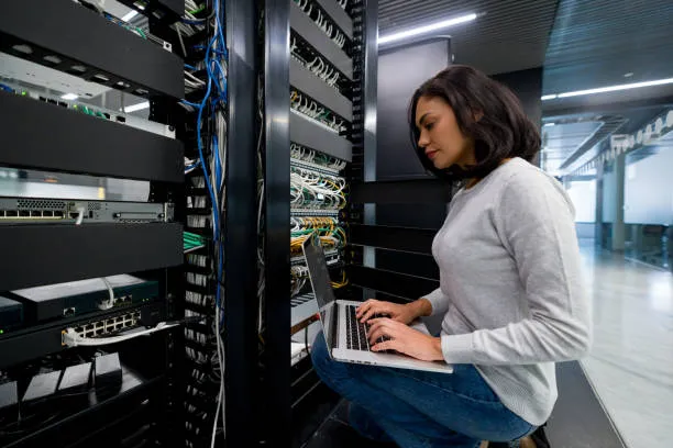 A female Computer Network Technician working on a laptop