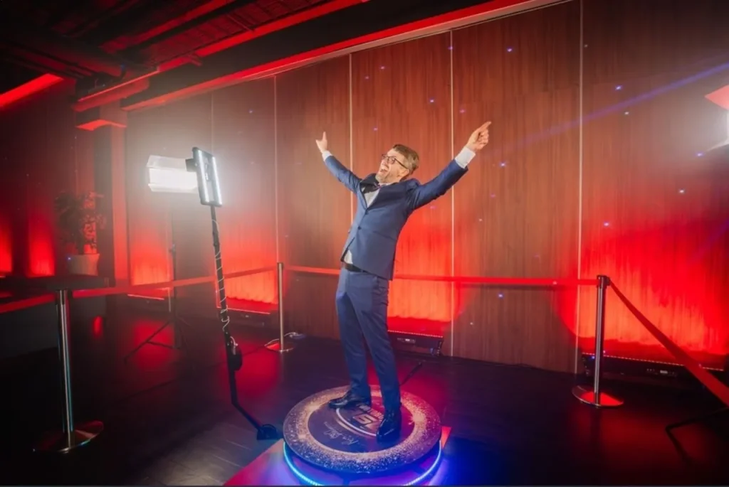 A man in suit capturing video on a 360 Booth during a corporate event