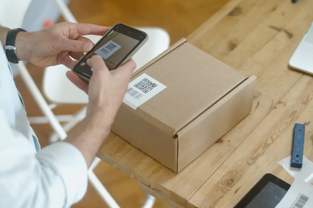 Using a smartphone to scan a QR code on a cardboard box