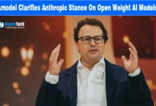 Anthropic CEO Dario Amodei speaking at a conference with hands raised.
