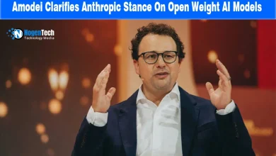 Anthropic CEO Dario Amodei speaking at a conference with hands raised.