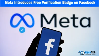 Smartphone showing the Facebook logo held in front of a screen displaying Meta branding and a blue verification badge icon.
