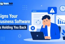 Frustrated businessman sitting at a laptop with error pop-ups and declining charts with NogenTech branding.