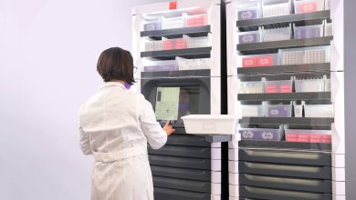 Person using an automated vertical storage system with organized shelves