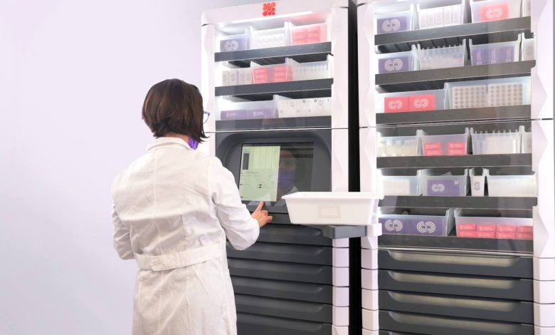 Person using an automated vertical storage system with organized shelves