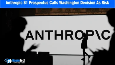 Silhouetted figures in front of a large illuminated Anthropic logo wall display.