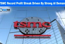 Red TSMC company logo mounted on a glass high-rise building exterior under a bright blue sky.